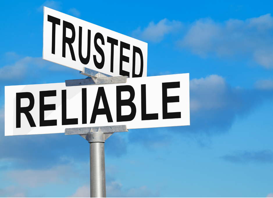 Two white street signs on a metal pole read "TRUSTED" and "RELIABLE" against a blue cloudy sky.